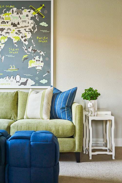 green couch and blue poufs at Plan 3 at Enliven