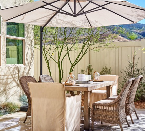 rattan and wood dining set on patio by Chameleon Design