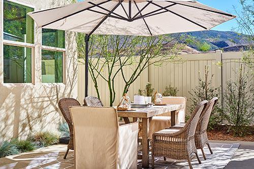 rattan and wood dining set on patio by Chameleon Design