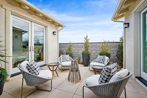 outdoor wicker chairs and wood table on patio by Chameleon Design