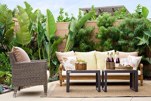 outdoor sofa, wicker chair, and tables on patio by Chameleon Design