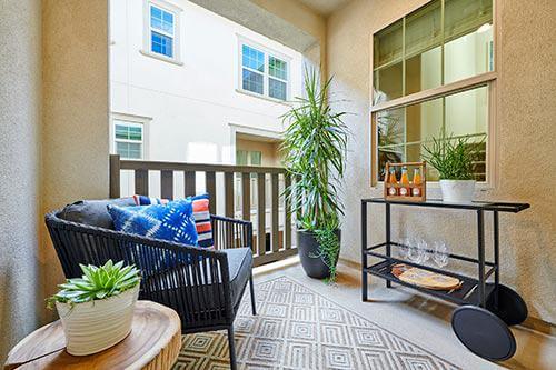 woven chair, wood slice table, and bar cart on deck by Chameleon Design