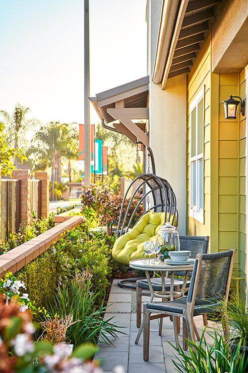 woven chairs and metal dining table on patio by Chameleon Design