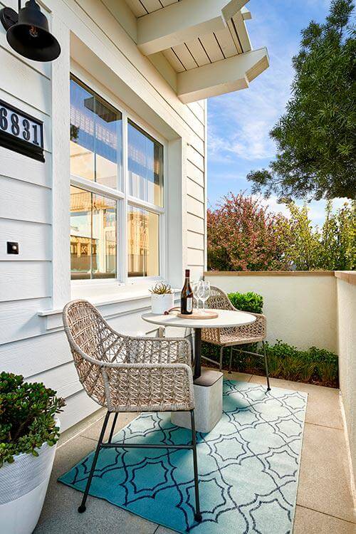 woven outdoor chairs and concrete table on patio by Chameleon Design