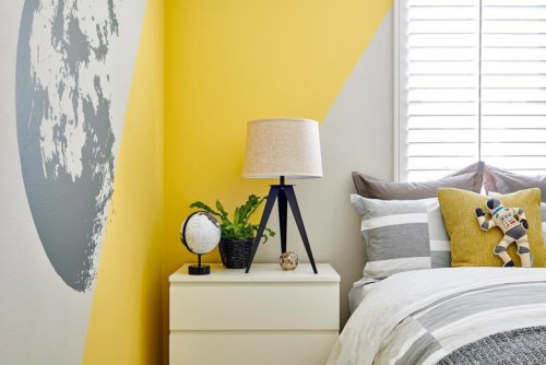 yellow and white painted wall with moon decal in space themed bedroom by Chameleon Design