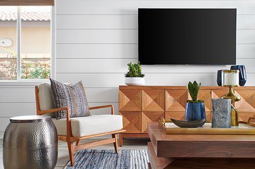 living room with white shiplap and wood media cabinet