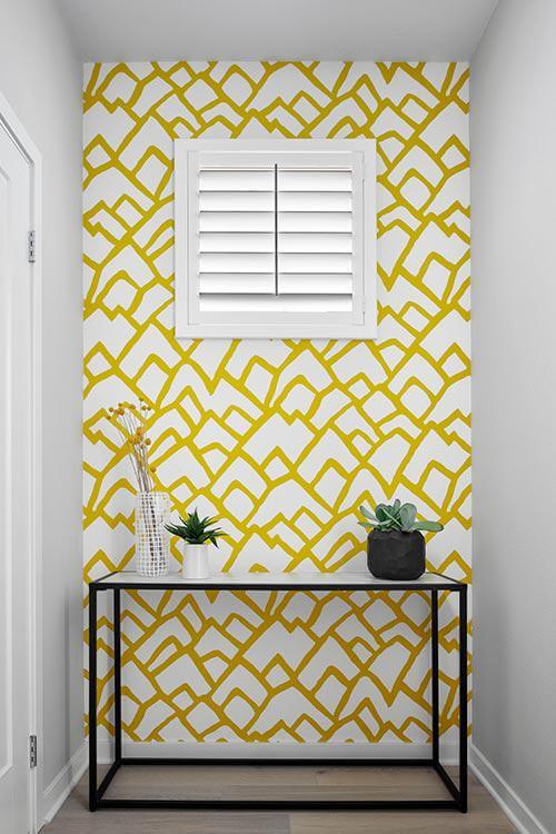 entryway with gold patterned wallpaper