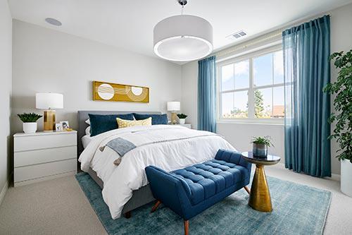 white bedroom with blue and gold accents