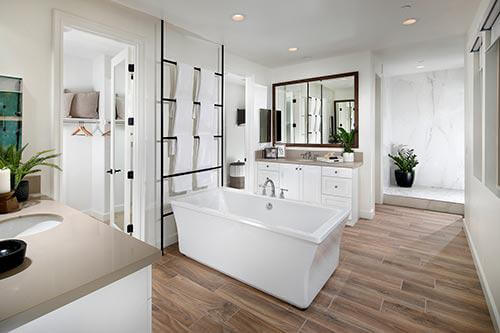 primary bathroom with white vanities and soaking tub