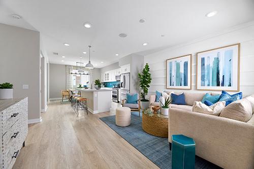open concept living room and kitchen with blue accents Townes at Magnolia Plan 2 Melia Homes