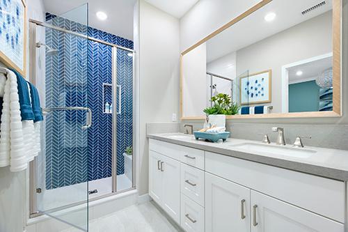 primary bath with blue shower tile and dual sinks Townes at Magnolia Plan 2 Melia Homes