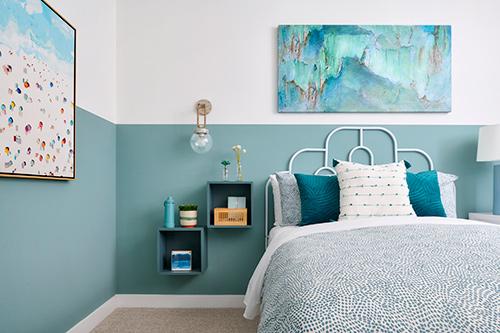 secondary bedroom with beach themed artwork and floating shelves Townes at Magnolia Plan 2 Melia Homes