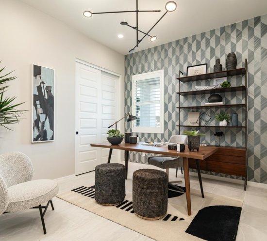 tonal gray hexagonal wallpaper, wood desk, matte black bookcase, cream and black area rug in home office Allevare