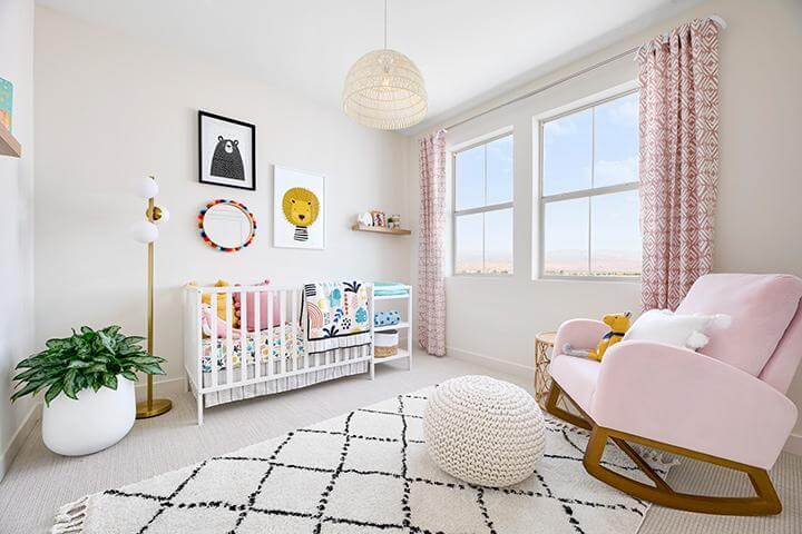 pink nursery with velvet rocking chair and plush rug