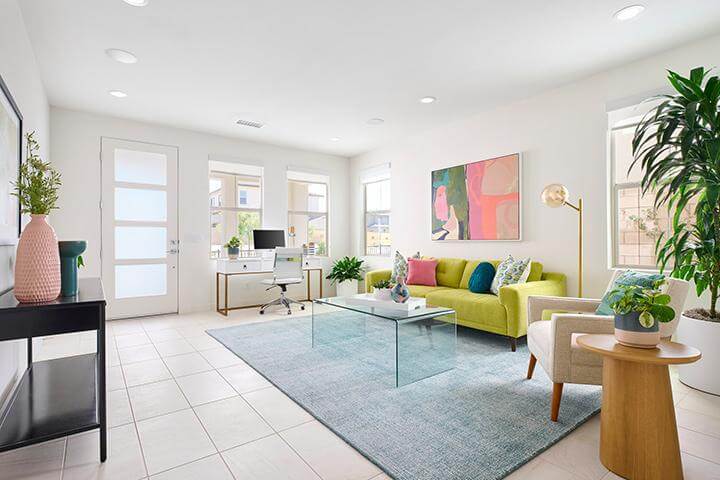 white living room with bright green sofa and colorful abstract art