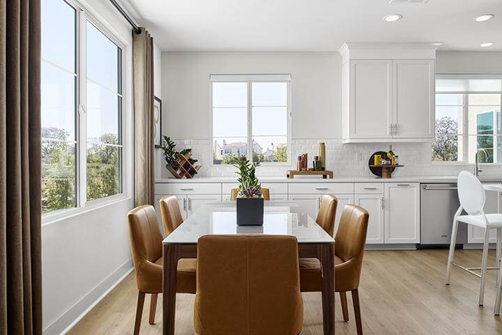 bright white dining area with dining table and leather dining chairs