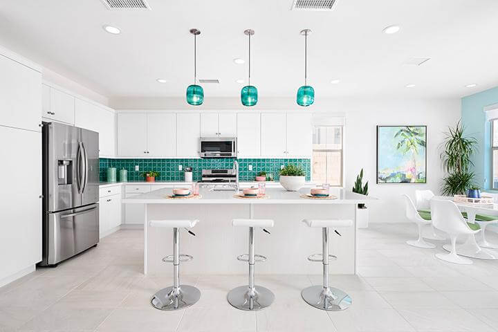 bright white kitchen with turquoise backsplash and pendant lights