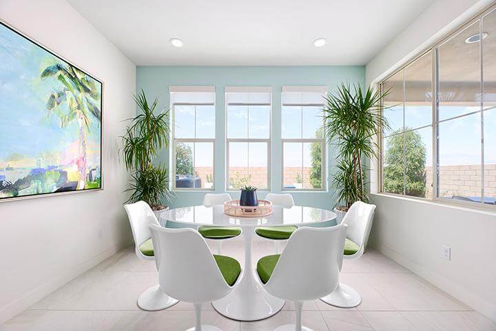 pastel dining room with modern art, plants, and white dining furniture
