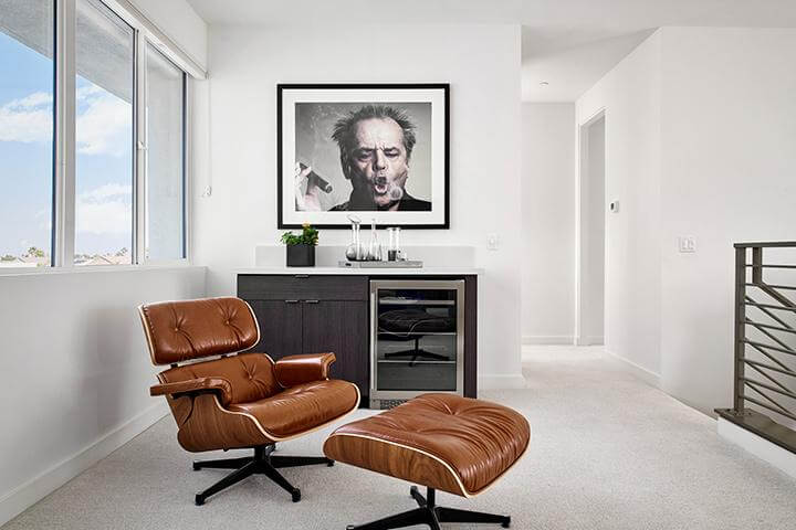 minimalist seating area with Jack Nicholson artwork and leather reclining chair with footrest