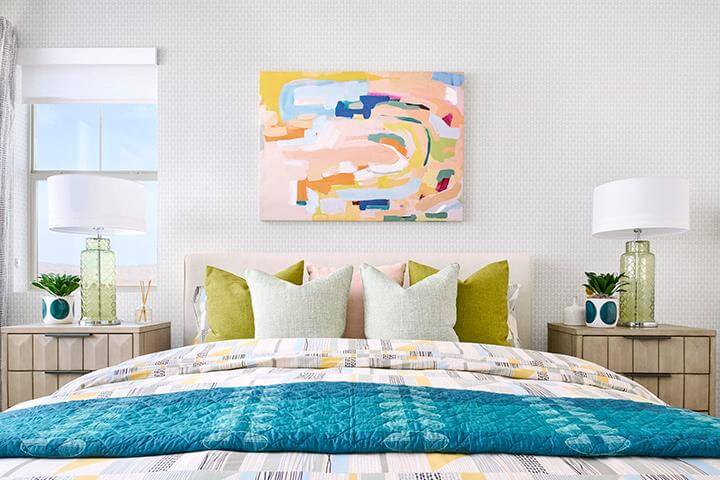 bedroom with colorful bedding and modern art