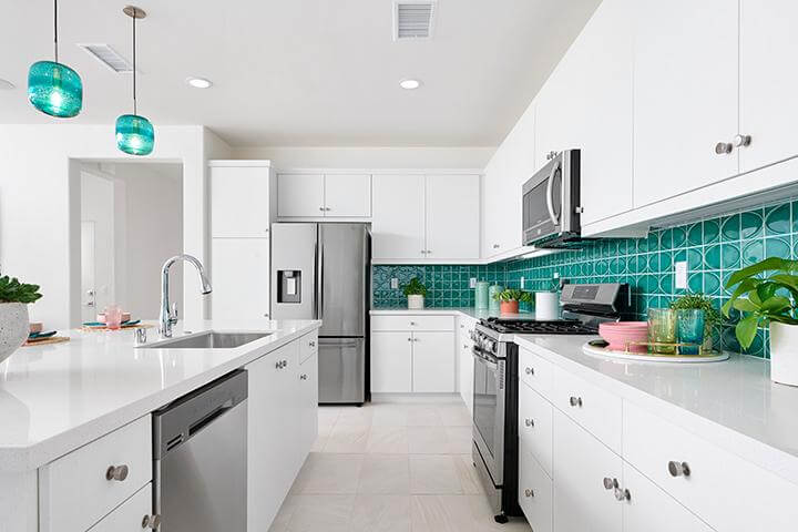 bright white kitchen with turquoise backsplash and stainless steel appliances