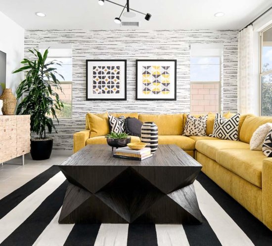 bold living room with yellow couch and black and white striped rug