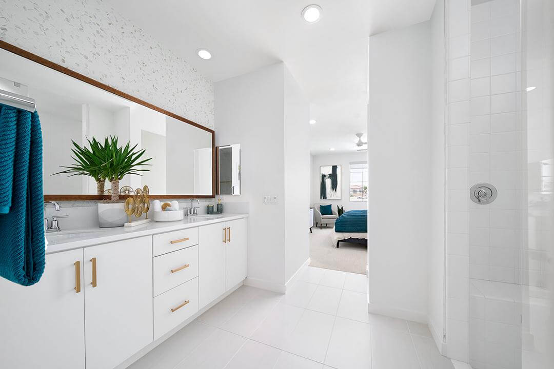 white bathroom with white cabinets and gold hardware