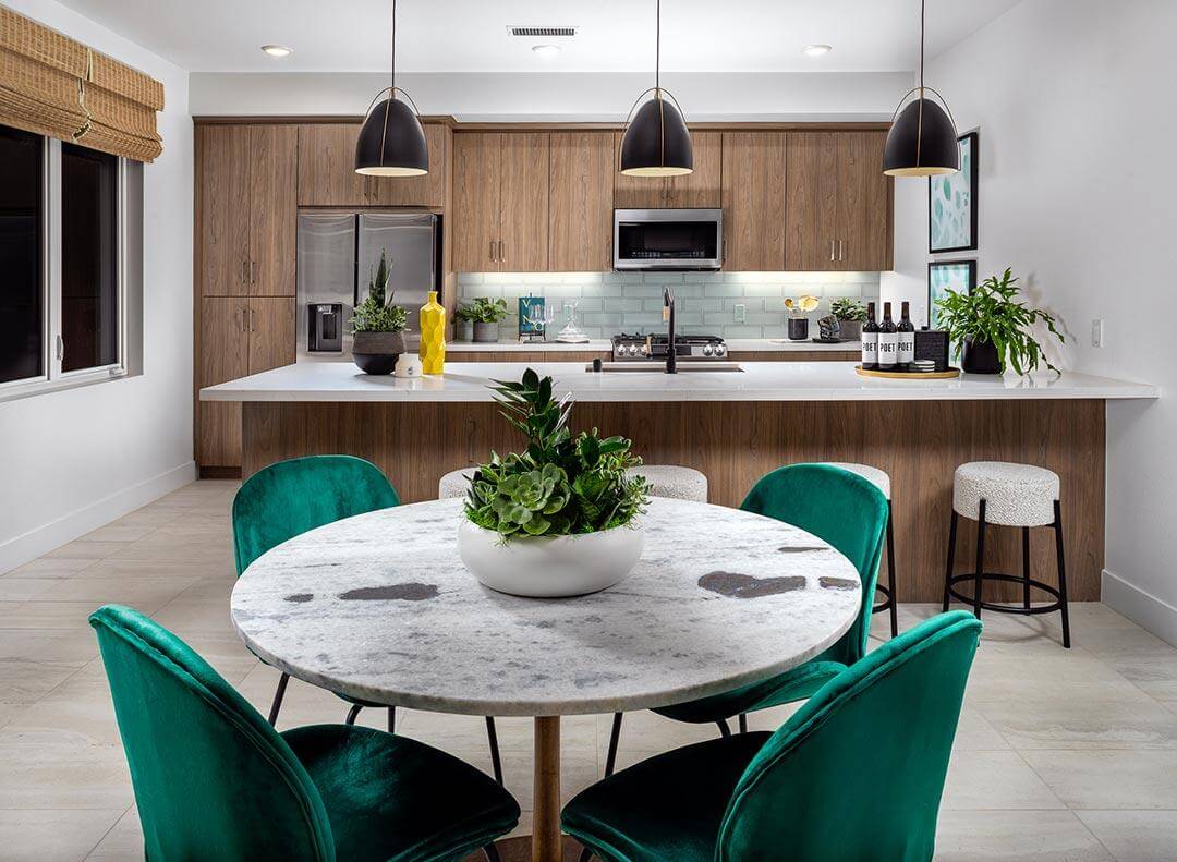 modern kitchen with wooden cabinet faces and green velvet chairs