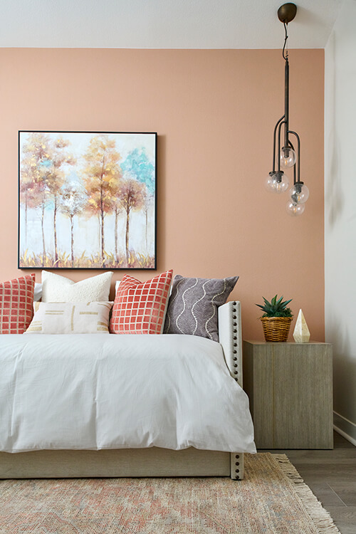 pink accent wall with daybed and modern light fixture
