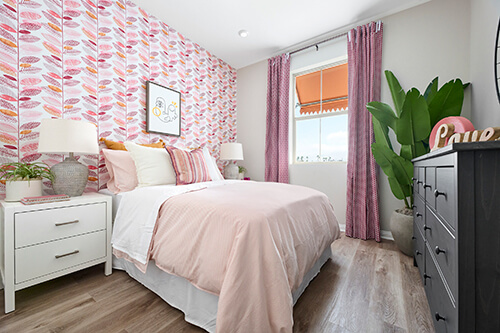 girls bedroom with pink wallpaper and curtains