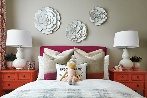 bedroom with red headboard orange side tables and dimensional art