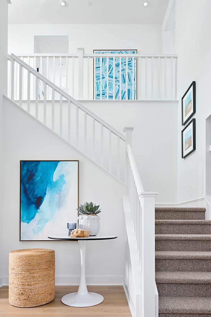 entryway staircase with natural accents and blue artwork