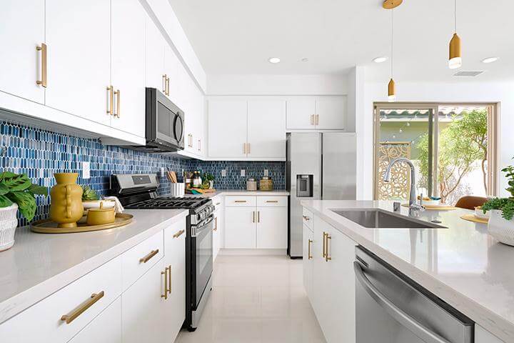 kitchen with blue backsplash and gold hardware