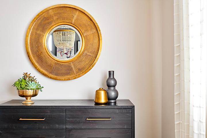 gold mirror above dresser with gold hardware