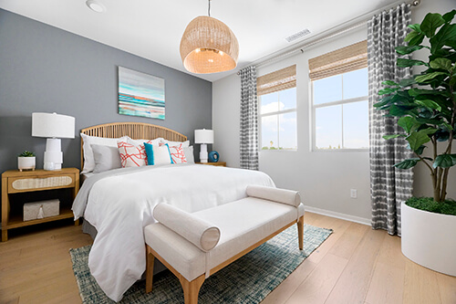 a rattan chandelier hangs in an airy bedroom