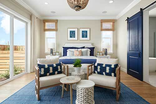 bedroom with club chairs and blue barn door